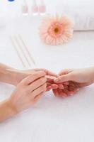 Cleaning nails. Close-up of beautician cleaning nails of female customer photo