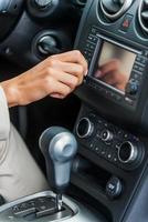 Examining her new car. Close-up of woman in formalwear touching dashboard with finger while sitting in car photo