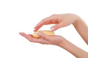 Keeping hands clean and fresh. Close-up of beautiful female hands holding soap bar while isolated on white photo