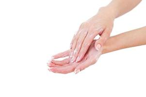 Keeping her hands clean. Close-up of woman washing hands with soap while isolated on white photo