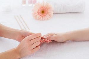 Nails cleaning. Close-up of beautician cleaning nails of female customer photo
