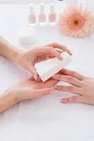 Polishing nails. Close-up of beautician polishing nails of female customer photo