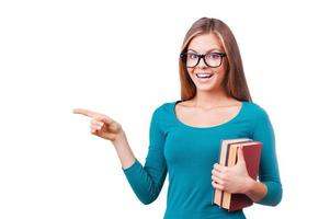 It is interesting. Beautiful young women looking at camera and pointing away while standing against white background. photo