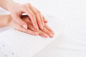 Smooth skin. Close-up of beautiful female hands on the towel photo