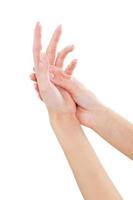 masajeando la mano. primer plano de hermosas manos femeninas aisladas en blanco foto