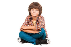 Little boy. Little boy keeping arms crossed while sitting isolated on white photo