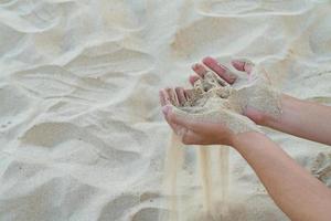 Sand in two hand with sandy floor background photo