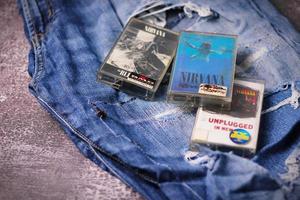 WASHINGTON USA - September 30 2022  Nirvana's cassette tape and Ripped jeans or Torn jeans. A symbol of the grunge or Seattle sound. photo