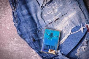 WASHINGTON USA - September 30 2022  Nirvana's cassette tape and Ripped jeans or Torn jeans. A symbol of the grunge or Seattle sound. photo