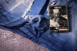 WASHINGTON USA - September 30 2022  Nirvana's cassette tape and Ripped jeans or Torn jeans. A symbol of the grunge or Seattle sound. photo