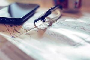 Map, map of Washington state, pen, glasses, cell phone, coffee cup on the table. photo