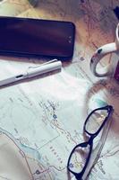 Map, map of Washington state, pen, glasses, cell phone, coffee cup on the table. photo