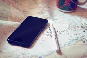 Map, map of Washington state, pen, glasses, cell phone, coffee cup on the table. photo