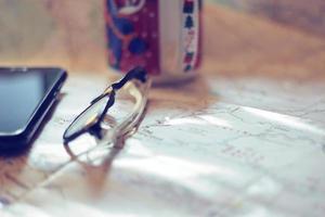 Map, map of Washington state, pen, glasses, cell phone, coffee cup on the table. photo