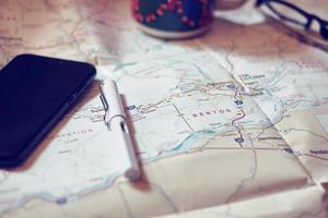 Map, map of Washington state, pen, glasses, cell phone, coffee cup on the table. photo