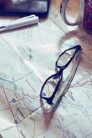 Map, map of Washington state, pen, glasses, cell phone, coffee cup on the table. photo