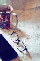 Map, map of Washington state, pen, glasses, cell phone, coffee cup on the table. photo