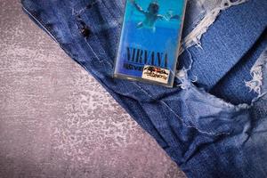 WASHINGTON USA - September 30 2022  Nirvana's cassette tape and Ripped jeans or Torn jeans. A symbol of the grunge or Seattle sound. photo