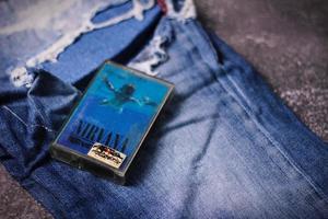 WASHINGTON USA - September 30 2022  Nirvana's cassette tape and Ripped jeans or Torn jeans. A symbol of the grunge or Seattle sound. photo