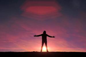 hombre caminando en la montaña con un fondo de puesta de sol en verano foto