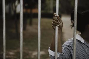 Hand of the prisoner on a steel lattice close up photo