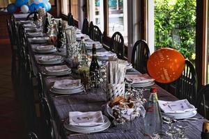 suntuosa mesa puesta para un almuerzo de fiesta en un restaurante durante un cumpleaños en el verano de 2022 foto