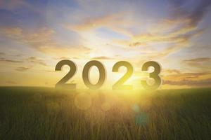 silueta año 2023 en pastizales vacíos y amanecer foto