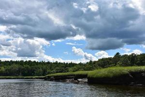 nubes oscuras sobre un río de marea y marismas foto