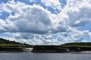Fluffy White Clouds Hanging Over Marsh Grass photo