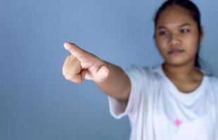 Female hand pushing a digital screen at white background. focus on finger. photo