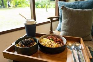 fusión asiática de comida tailandesa y japonesa, incluido arroz con cerdo y huevos revueltos servidos con bebida en el restaurante foto