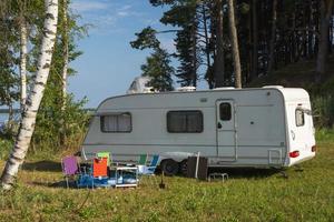 Camper trailer in nature on the background of the lake, tourism, travel, outdoor recreation, active lifestyle photo