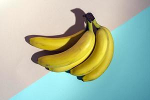 yellow bananas on a pink and turquoise background, pattern, minimalism, healthy food photo