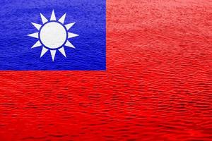 Taiwan flag or Taiwanese banner on a water surface texture with small ripples. photo