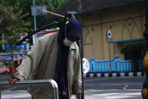 Magelang, Indonesia, 2022 - photo of an old woman walking on the sidewalk in the afternoon