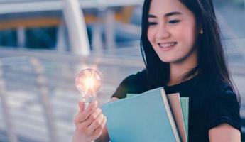 joven estudiante universitario con bombilla, idea creativa, los pensamientos tienen poder, el poder de pensar ideas. foto