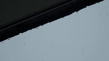 Rain and roof. Falling rain from the roof. Rain drops flow down from a roof down. video