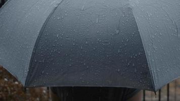 Rain on grey umbrella. Silver umbrella in the rain on evening Bangkok. video