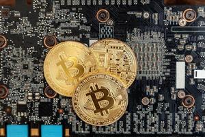 Cryptocurrency golden bitcoin coin lying on video card. Electronic virtual money for web banking and international network payment. Symbol of crypto virtual currency. Mining concept. photo