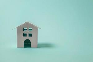 Simply design with miniature white toy house isolated on blue pastel colourful trendy background. Mortgage property insurance dream home concept. Copy space. photo