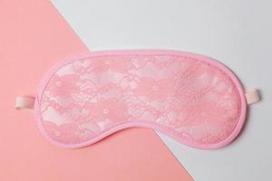 Sleeping eye mask, isolated on white and pink pastel colorful trendy geometric background. Do not disturb me, let me sleep. Rest, good night, insomnia, relaxation, tired, travel concept. photo