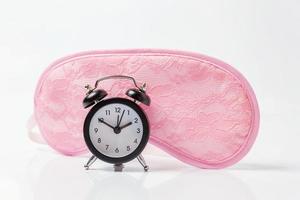 Sleeping eye mask, alarm clock isolated on white background. Do not disturb me, let me sleep. Rest, good night, siesta, insomnia, relaxation, tired, travel concept. photo