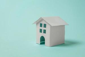 Simply design with miniature white toy house isolated on blue pastel colourful trendy background. Mortgage property insurance dream home concept. Copy space. photo
