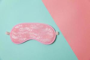 Sleeping eye mask alarm clock isolated on blue pink pastel colorful trendy geometric background. Do not disturb me, let me sleep. Rest, good night, siesta, insomnia, relaxation, tired, travel concept. photo