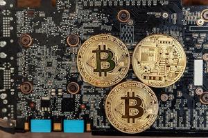 Cryptocurrency golden bitcoin coin lying on video card. Electronic virtual money for web banking and international network payment. Symbol of crypto virtual currency. Mining concept. photo