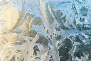 Frozen winter window with shiny ice frost pattern texture. Christmas wonder symbol, abstract background. Extreme north low temperature, natural Ice snow on frosty glass, cool winter weather outdoor. photo