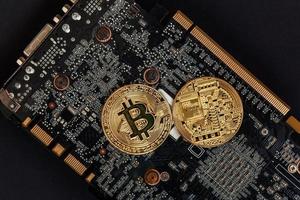 Cryptocurrency golden bitcoin coin lying on video card. Electronic virtual money for web banking and international network payment. Symbol of crypto virtual currency. Mining concept. photo