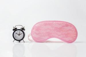 Sleeping eye mask, alarm clock isolated on white background. Do not disturb me, let me sleep. Rest, good night, siesta, insomnia, relaxation, tired, travel concept. photo