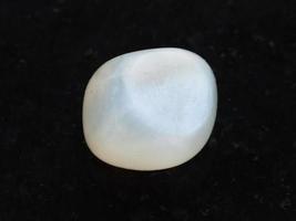 polished translucent moonstone gemstone on dark photo