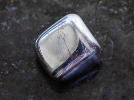 tumbled hematite stone on dark background photo